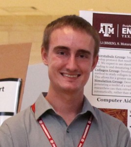 Man in a gray shirt with a red lanyard around his neck